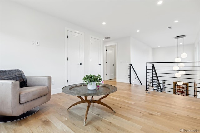 sitting room featuring recessed lighting, visible vents, an upstairs landing, light wood-type flooring, and baseboards