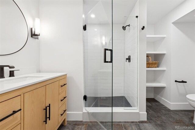 full bathroom featuring toilet, a stall shower, vanity, and baseboards