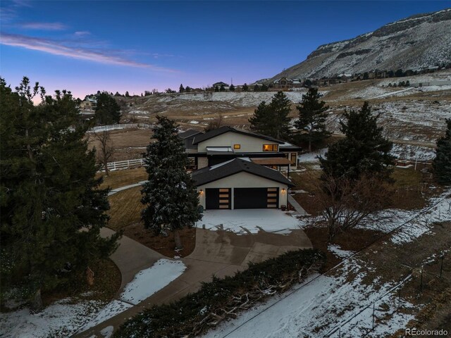 view of front of home with a garage, a mountain view, and concrete driveway