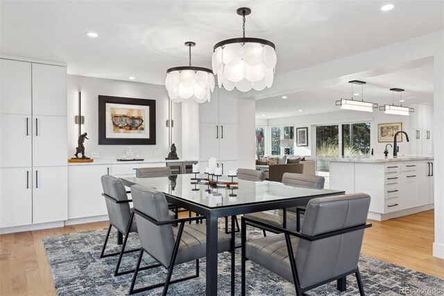 dining space with a notable chandelier, recessed lighting, and light wood-style floors