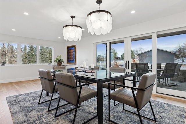 dining room featuring recessed lighting, wood finished floors, and an inviting chandelier