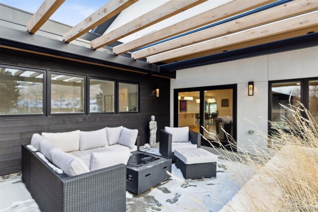 snow covered patio with an outdoor living space with a fire pit and a pergola