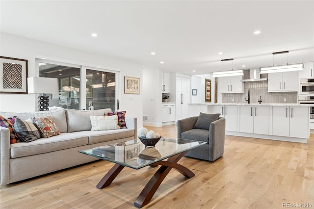 living room featuring light wood-style flooring and recessed lighting