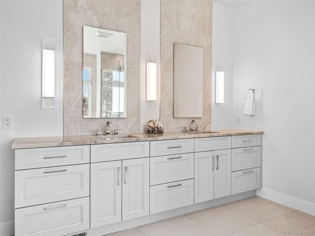 full bath featuring double vanity, baseboards, visible vents, and a sink