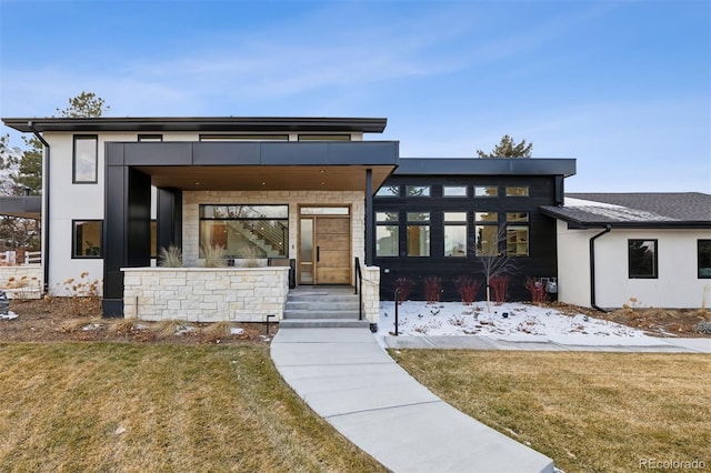 modern home featuring a front yard and stucco siding