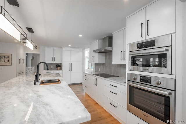17326 W 57th Ave, Golden, CO 80403 - kitchen with a sink, wall chimney range hood, black electric stovetop, decorative backsplash, and stainless steel double oven