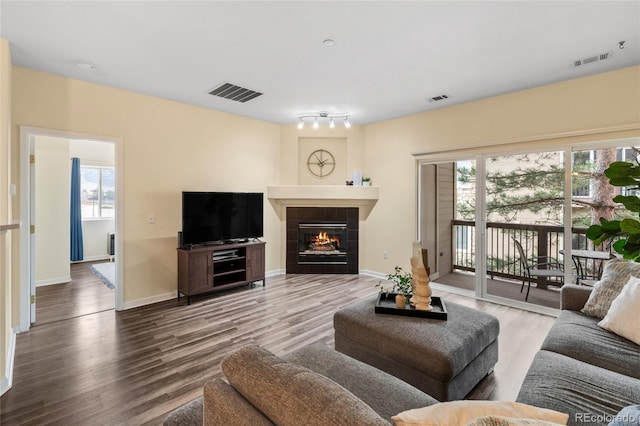 living room featuring a fireplace, wood finished floors, and visible vents