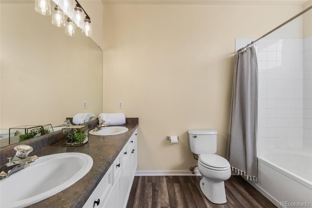 bathroom with wood finished floors, toilet, baseboards, and a sink