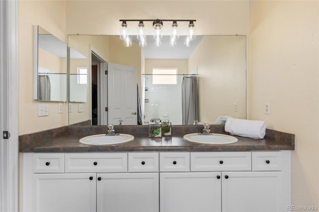 bathroom featuring curtained shower, double vanity, and a sink