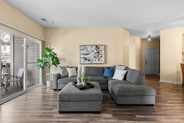 living room featuring wood finished floors, visible vents, and baseboards