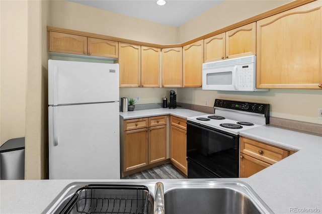 kitchen with light brown cabinetry, white appliances, and light countertops