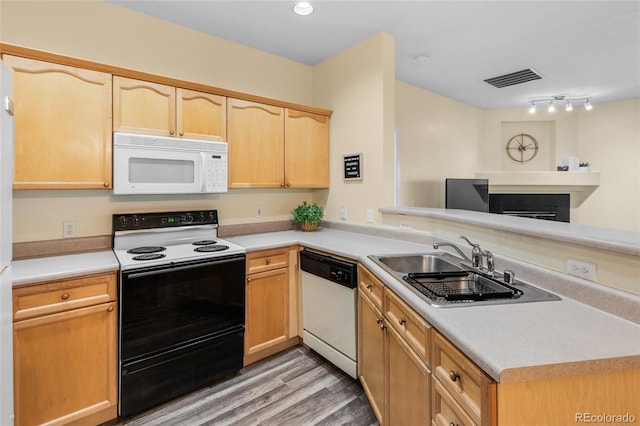 kitchen with white appliances, light brown cabinets, visible vents, a sink, and light countertops