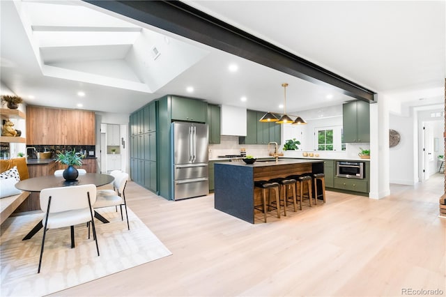 11010 W 29th Ave, Lakewood, CO 80215 - kitchen featuring stainless steel appliances, green cabinets, backsplash, an island with sink, and a kitchen bar