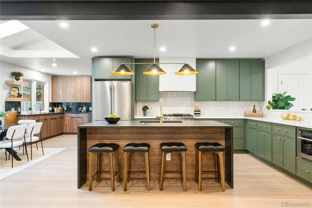 11010 W 29th Ave, Lakewood, CO 80215 - kitchen with appliances with stainless steel finishes, green cabinetry, backsplash, a kitchen breakfast bar, and recessed lighting