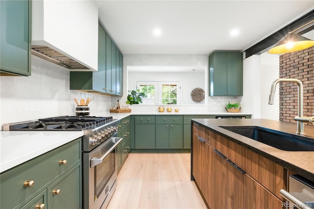 11010 W 29th Ave, Lakewood, CO 80215 - kitchen with stainless steel stove, green cabinets, light wood-style flooring, custom range hood, and recessed lighting