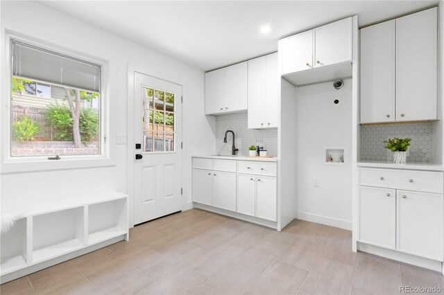11010 W 29th Ave, Lakewood, CO 80215 - kitchen featuring light countertops, tasteful backsplash, and white cabinetry