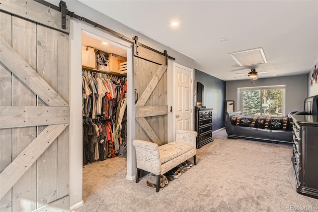 bedroom featuring ceiling fan, a walk in closet, carpet floors, and a closet