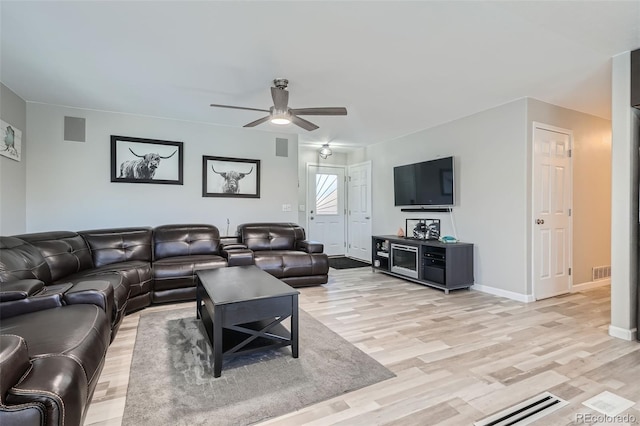 living room with light hardwood / wood-style flooring and ceiling fan