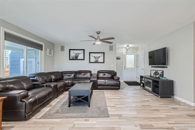 living room with ceiling fan and light wood-type flooring