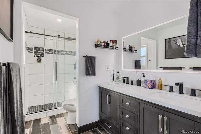 bathroom with toilet, vanity, an enclosed shower, and hardwood / wood-style flooring