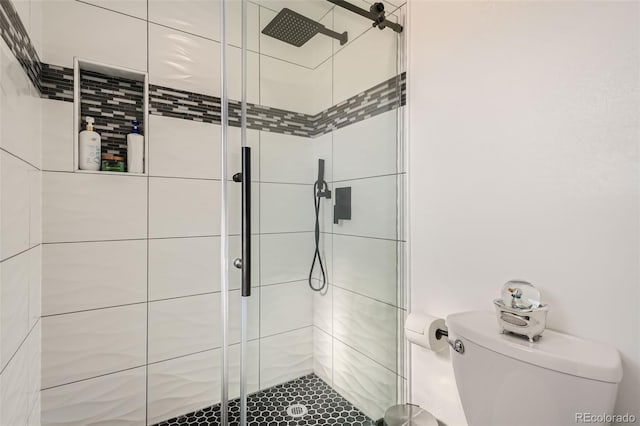 bathroom with toilet and a shower with shower door