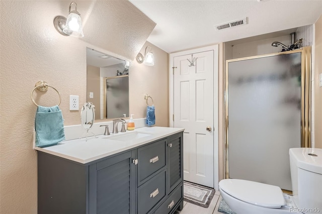 bathroom with vanity, an enclosed shower, a textured ceiling, and toilet