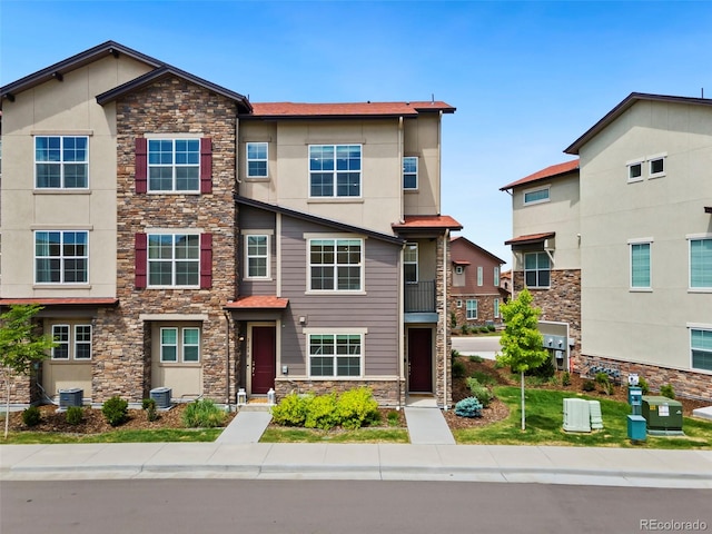 2140 Santini Trl Unit F, Littleton, CO 80129 - townhome / multi-family property featuring stone siding, central air condition unit, and stucco siding