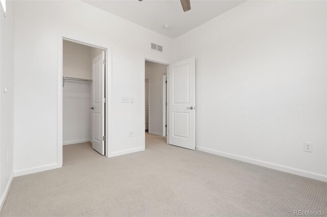 2140 Santini Trl Unit F, Littleton, CO 80129 - unfurnished bedroom featuring light colored carpet, baseboards, a walk in closet, and ceiling fan