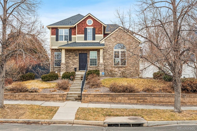 view of front of property featuring roof with shingles and brick siding