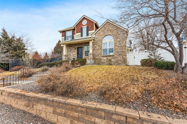 view of front facade featuring brick siding and fence