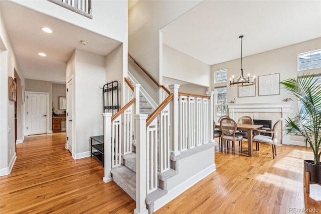 stairs featuring wood finished floors, a wealth of natural light, and baseboards