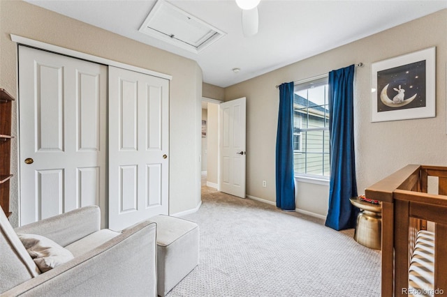 bedroom featuring light colored carpet, a ceiling fan, baseboards, a closet, and attic access