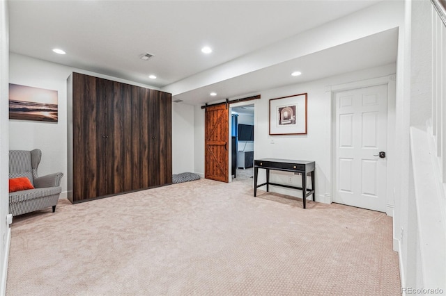 living area with recessed lighting, light carpet, visible vents, and a barn door