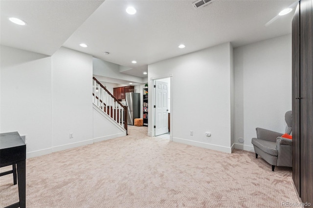 below grade area with light carpet, stairway, baseboards, and recessed lighting