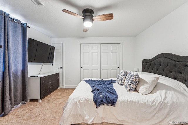 bedroom with a closet, visible vents, a ceiling fan, light carpet, and baseboards