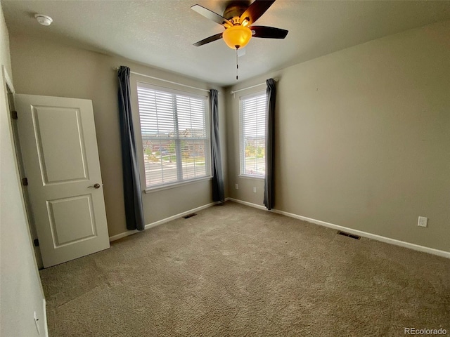 carpeted empty room featuring ceiling fan