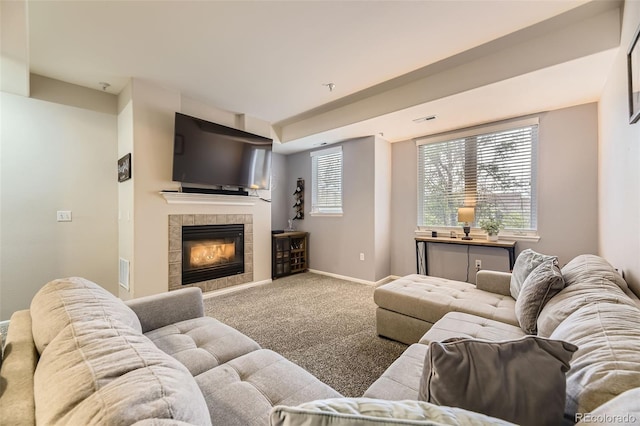 living area with baseboards, carpet flooring, a tile fireplace, and visible vents