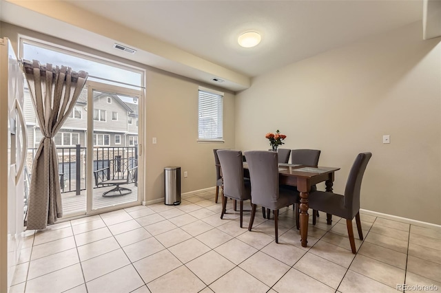 dining area featuring light tile patterned flooring, baseboards, and visible vents