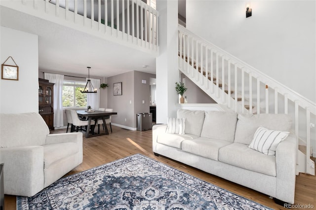 4304 S Genoa Ct, Centennial, CO 80015 - living room featuring wood finished floors, stairs, a chandelier, and a towering ceiling