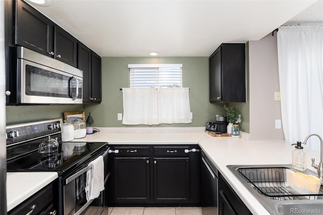 4304 S Genoa Ct, Centennial, CO 80015 - kitchen with appliances with stainless steel finishes, dark cabinetry, light countertops, and light tile patterned flooring