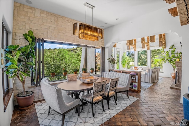 dining space featuring a towering ceiling and a notable chandelier