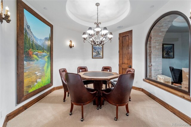 7944 Dante Dr, Littleton, CO 80125 - dining space with a tray ceiling, baseboards, carpet floors, and a chandelier
