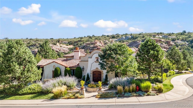 7944 Dante Dr, Littleton, CO 80125 - view of front facade featuring a tiled roof, stucco siding, and a chimney
