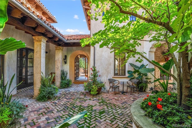 property entrance featuring a patio and french doors