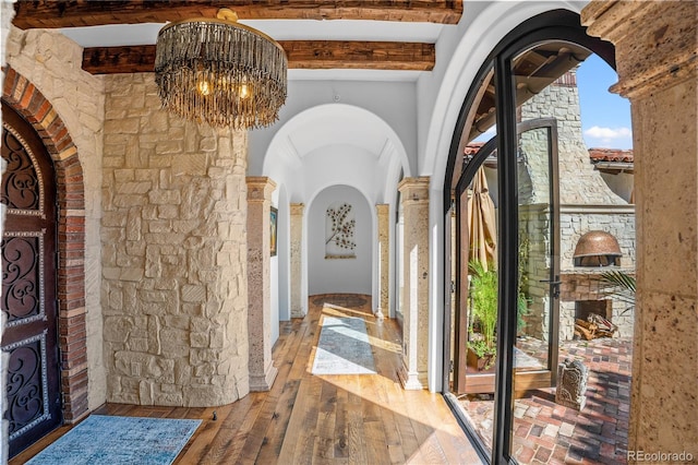 7944 Dante Dr, Littleton, CO 80125 - entrance foyer with plenty of natural light, arched walkways, beam ceiling, hardwood / wood-style flooring, and a notable chandelier