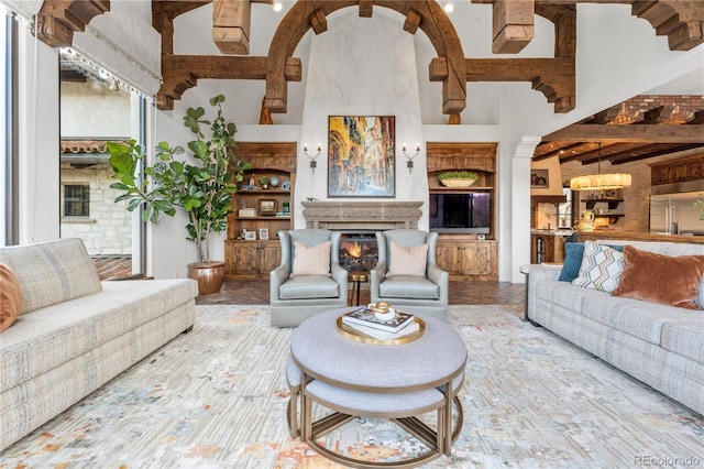 7944 Dante Dr, Littleton, CO 80125 - living area with a lit fireplace, a high ceiling, and beam ceiling