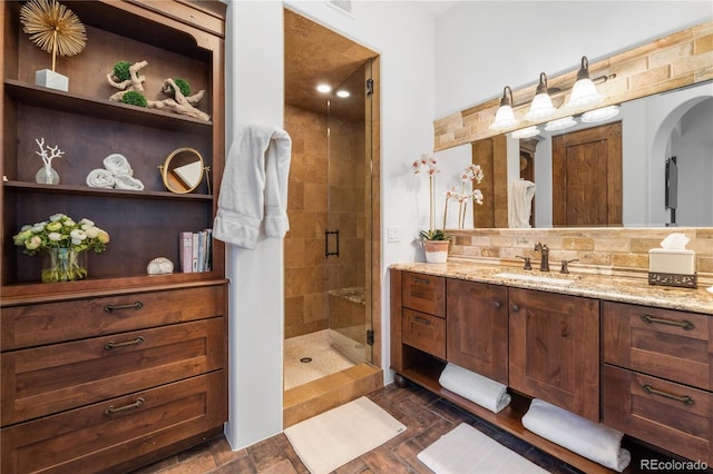 bathroom with backsplash, a shower with door, vanity, and hardwood / wood-style flooring