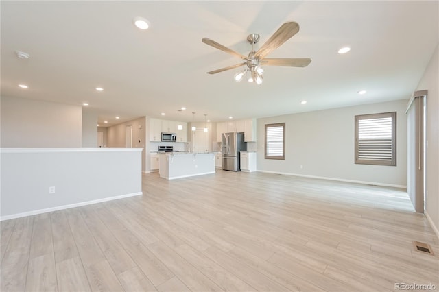 unfurnished living room featuring light hardwood / wood-style flooring and ceiling fan