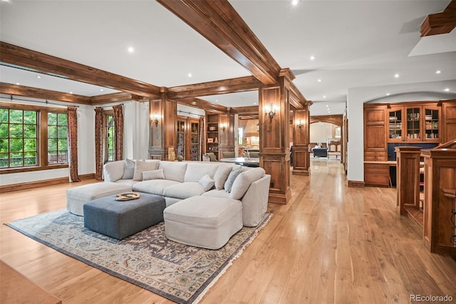 living room with light wood-style floors, baseboards, beam ceiling, recessed lighting, and arched walkways