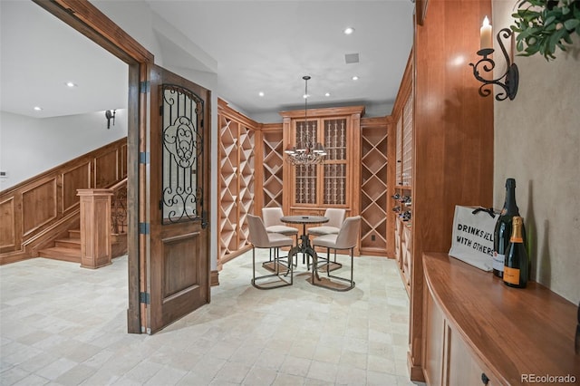 wine cellar with recessed lighting, a wainscoted wall, and a decorative wall